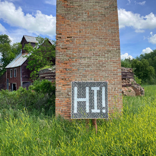 Erin Kroeker of The Blanket Statement holding up HI! quilt made from a free pattern
