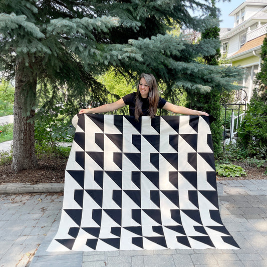 Erin Kroeker of The Blanket Statement holding The Hi Quilt, a free downloadable quilt pattern. Introduction blog post.